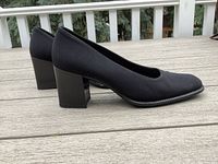 Side profile view of the pair of black Calderone heels showing the square toe, block heel, and overall design.