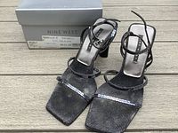 Front and top view of Nine West heeled sandals on wooden surface with original box visible.