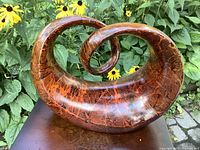 Close-up photo showing detailed texture and shape of the sculpture with a cracked pattern on surface