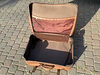 Open view of the suitcase interior showing the single compartment and fabric pocket in the lid.