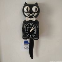 Full front view of black cat-shaped reproduction Kit Kat Klock wall clock showing the clock face, ears, eyes, and swinging tail.