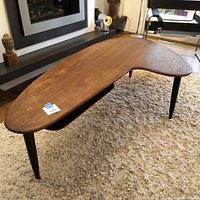 Angled front view showing boomerang tabletop and floating shelf