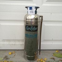 Front view of vintage chrome fire extinguisher showing full body and side spout.