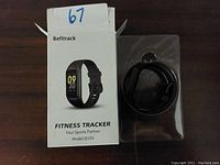 Photo shows the Befitrack Fitness Tracker in its blister pack beside original product box with model and branding visible.