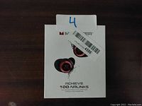 Front view of the retail packaging showing a pair of black and red wireless earbuds and product name.