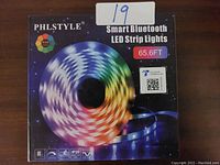 Boxed PHLSTYLE Smart Bluetooth LED Strip Lights, 65.6 feet length, RGB, with IP20 rating visible.