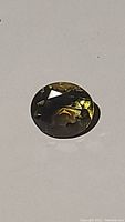 Oval cut bicoloured quartz gemstone showing lemon and smoky hues in facets
