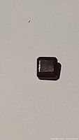 Close-up photo of 1.72ct emerald cut cherry red garnet on plain background