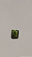 Rectangular cut natural green tourmaline gemstone showing deep forest green color and clarity.