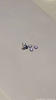 Six oval cut natural tanzanite gemstones arranged on a light surface with some reflected light.