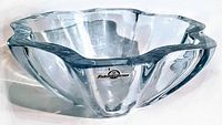 Clear thick glass art bowl with flared, organic edges. Visible original black and white Strombergshyttan Sweden paper label on the side.