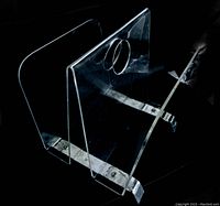 Side perspective showing clear lucite panels and curved chrome base with mounting screws.