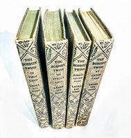 Four vintage Bobbsey Twins hardcover books standing side by side showing their spines with titles and author.