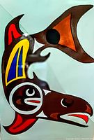 Front view of oil painting on canvas showing stylized bird motif with brown, red, yellow and blue design on light background