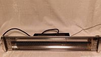 Full front view of the outdoor heat lamp showing the protective metal grill and heating element inside.