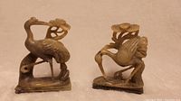 Front and side view of the pair of carved stone crane figurines showing detailed feathers and bases