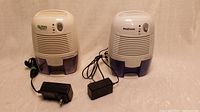 Photo showing both small dehumidifiers side-by-side with their respective power adapters.