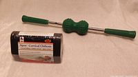 Photo showing the green handled Nikken magnetic therapy massage roller along with the sealed black Apex Cervical Orthosis pack.