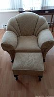 Front view of armchair with ottoman in matching upholstery