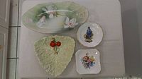 Four antique and vintage dishes laid on white surface showing details and overall condition