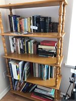 Full view of the four-tier solid wood bookshelf filled with books of various sizes and genres.