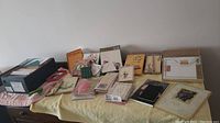 Wide view of assorted boxed and unboxed greeting cards and stationery sets arranged on a table.