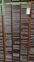 Photo of a wooden CD storage rack filled with CDs organized vertically