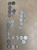 Overhead view of all 30 Canadian fifty cent coins arranged on beige surface