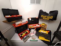 Overview of multiple storage cases, evidence collection supplies and duffel bag on freezer top