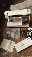 Full view of Kenmore sewing machine with accessory box containing threads and sewing supplies, manual, foot pedal and power cord