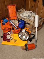 Overall view of duffel bag with rope, cases, spotlight, buoy, flare, beacons and streamer