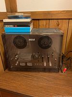 Full view of recorder on wood surface with stack of tapes on top