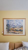 Full view of framed print hanging on wall above bed.