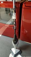 Full view of the Bonaire steam floor mop standing upright showing the handle, power cord, and triangular mop head.