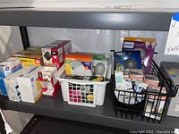 Shelves holding various boxed and loose light bulbs of different brands and sizes.
