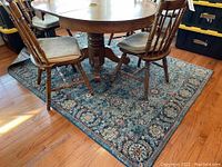 Full view of the Nourison area rug under a wooden dining table and chairs showing size and general condition.