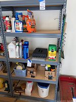 Full view of shelving unit showing metal frame and particle board shelves with various gardening and household items (not included).