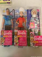 Three Barbie 'You Can Be Anything' dolls in original packaging. Includes soccer player, chef, and astronaut. Packaging shows brand and series clearly.