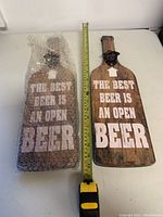 Photo showing two plaques, one in bubble wrap, and measuring tape indicating height about 20 inches.