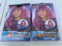 Two Disney Descendants 2 Mal wigs in original packaging, showing front of packages with a child model wearing the wig and product branding.