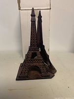 Photo showing front angle of one Eiffel Tower bookend with box in the background