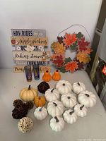 Full lot view showing wall plaques, pumpkins, pinecones, decorative balls, salt and pepper shakers, shot glasses, and wreath.
