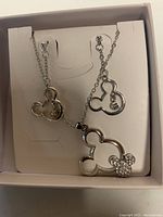Photo of platinum plated Mickey Mouse necklace and two matching earrings in white display box