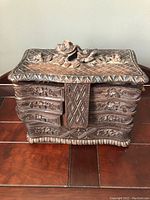 Front view of the vintage hand carved wooden jewellery box showing floral and geometric carved details.