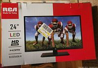 Box front showing 24" RCA LED HD Ready TV with image of football players on screen, model RLED2445A-H, HDMI input.