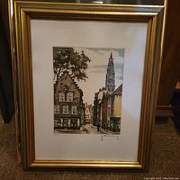 Framed lithograph showing the cityscape artwork clearly visible with signature and numbering 8/250 at the bottom right, in golden frame with white matting.