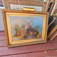 Framed original still life painting on board featuring fruit and a pink pitcher, with a picture light mounted on the frame.