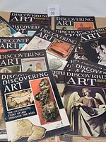 Collection of 27 'Discovering Art' magazines spread out showing colorful covers with art images including sculptures and historical paintings.