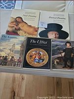Set of five art and painting books arranged on a white surface. Covers show classical paintings including nude art and portraits.