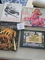 Four art books laid out on a flat surface, showing cover art and titles.